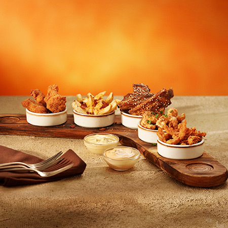 Big Five Boomerang - Porções de aperitivos em uma mesa com dois potes com molho e talheres.